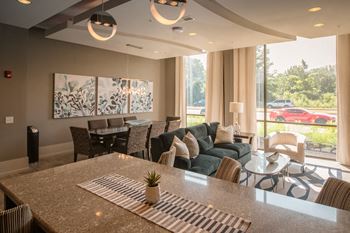 a living room with a couch and a table in front of a large window  at Avant & Avant II, Carmel, 46032